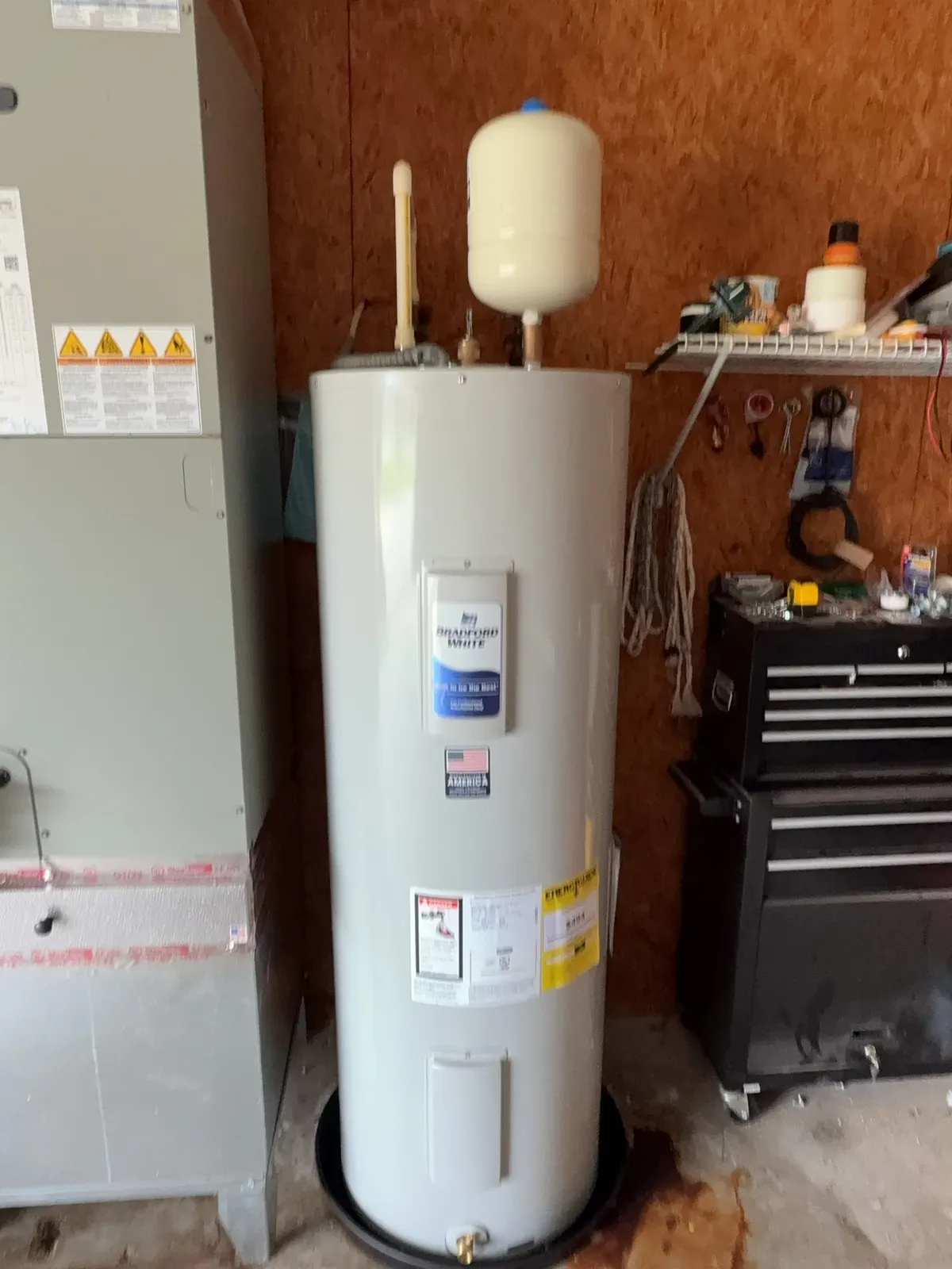 New Bradford White electric water heater in a drain pan with an expansion tank mounted on top